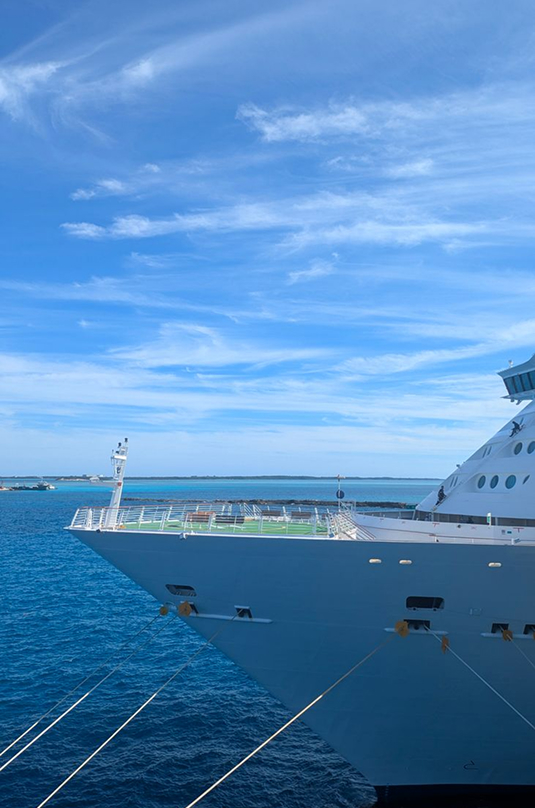 Bow of a cruise ship moored in clear blue water