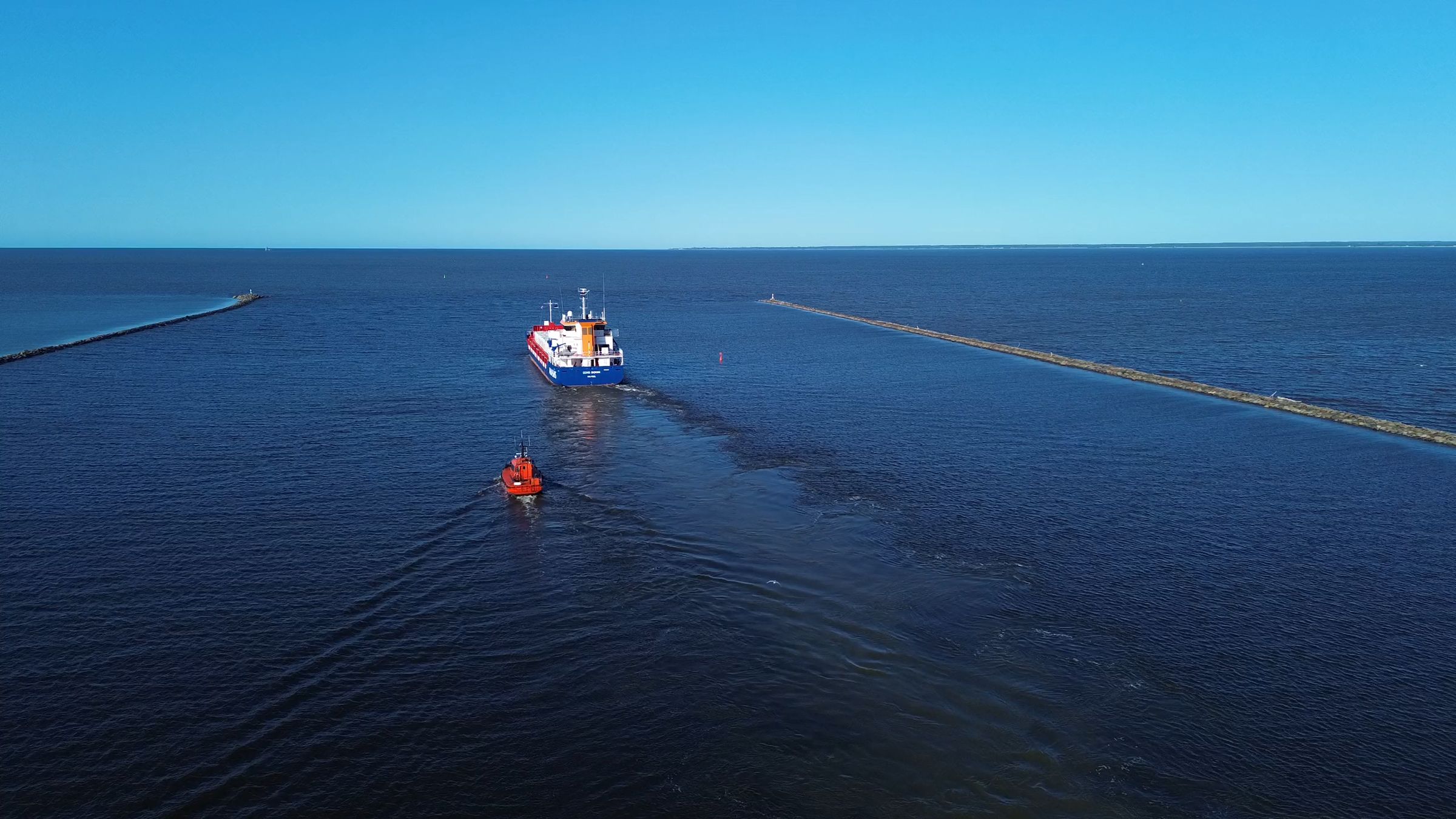 Tugboat escorting a cargo ship out of harbor