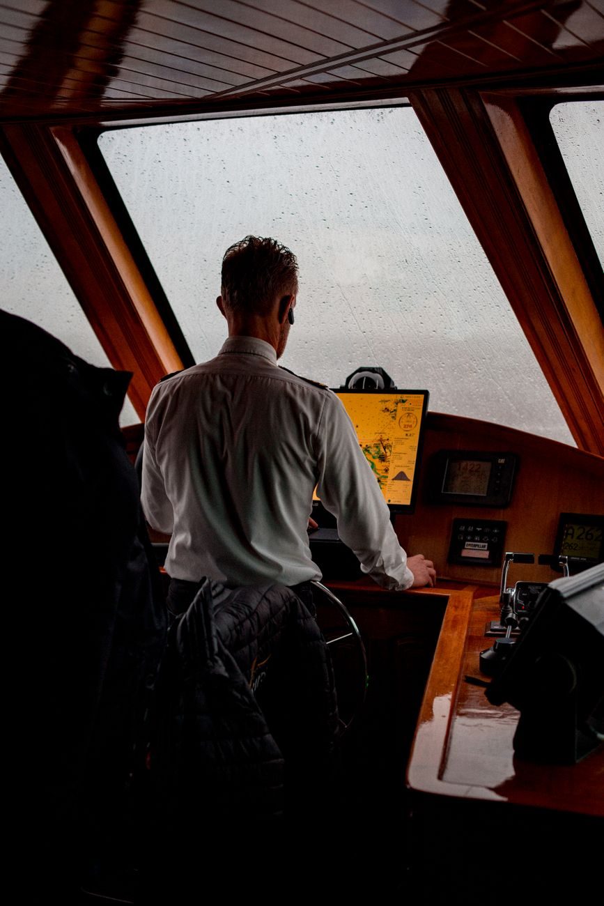 Captain steering a vessel from the wheelhouse